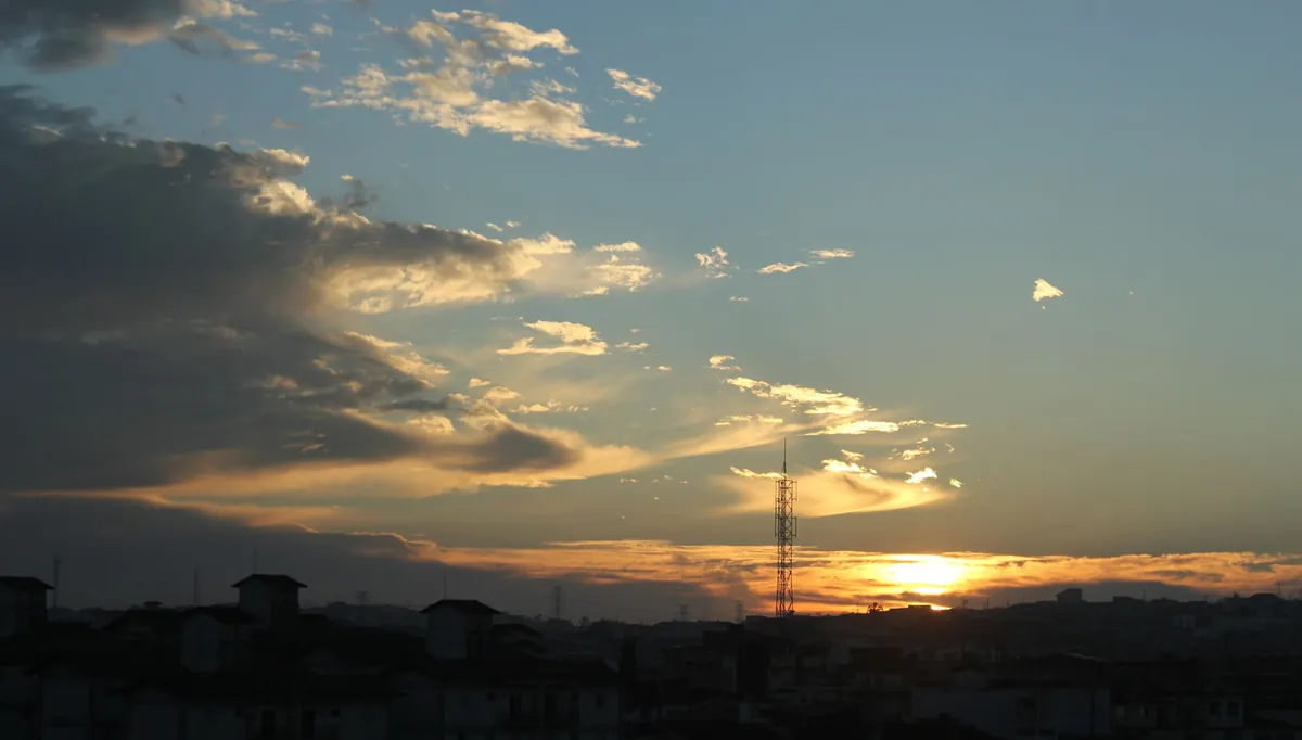 Silhueta de cidade ao pôr do sol com céu alaranjado